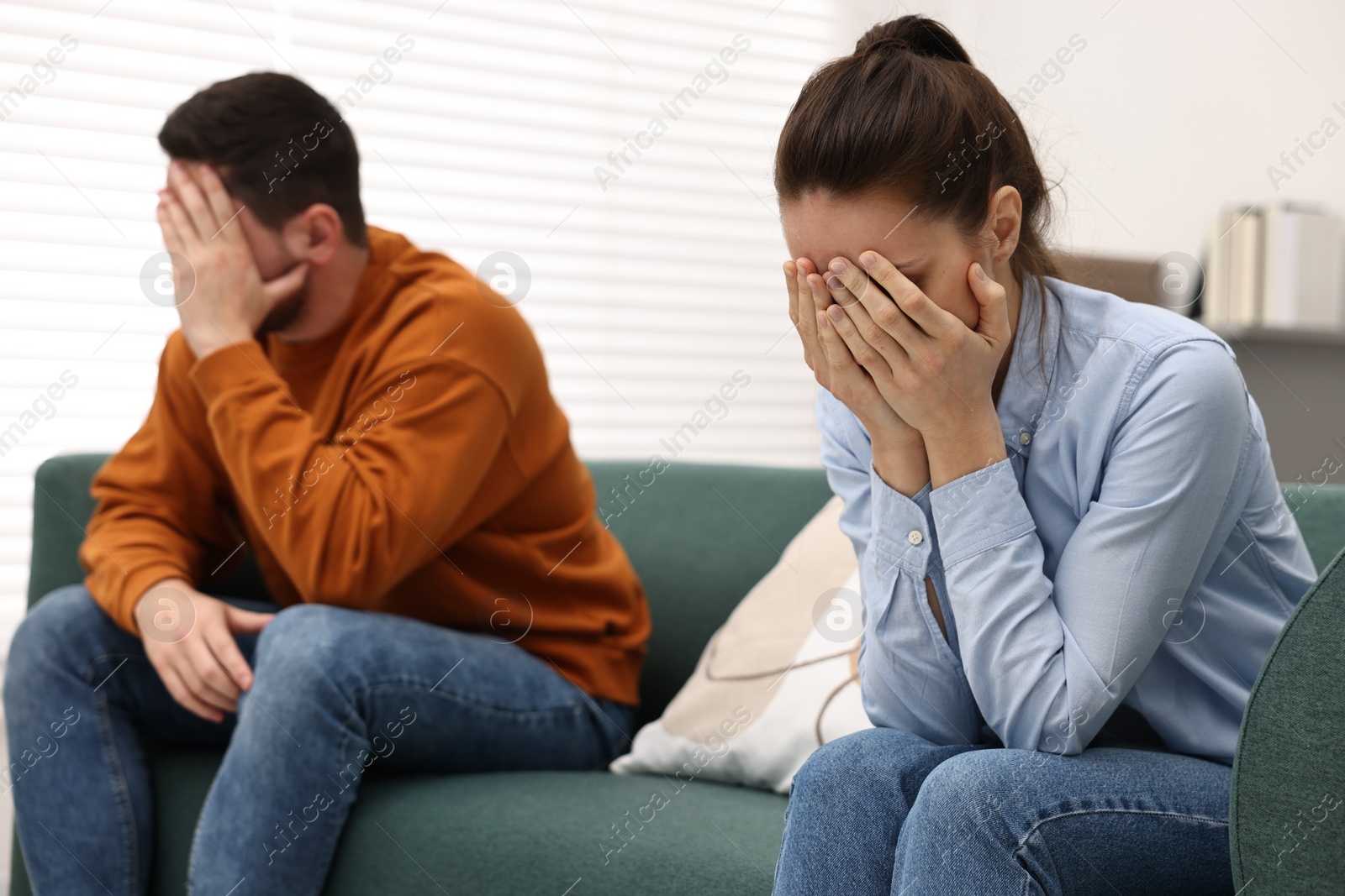 Photo of Offended couple ignoring each other after quarrel indoors, selective focus. Relationship problems