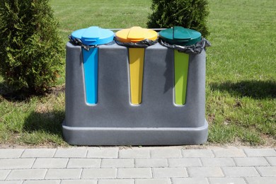 Photo of Recycling bins for different garbage outdoors. Waste sorting