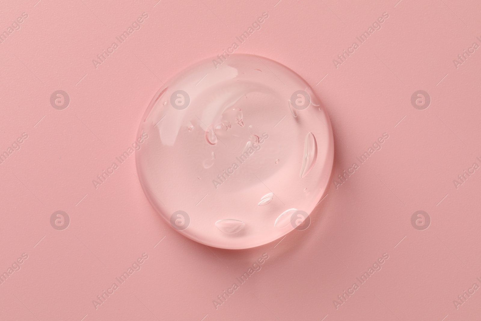 Photo of Sample of clear cosmetic gel on pink background, top view