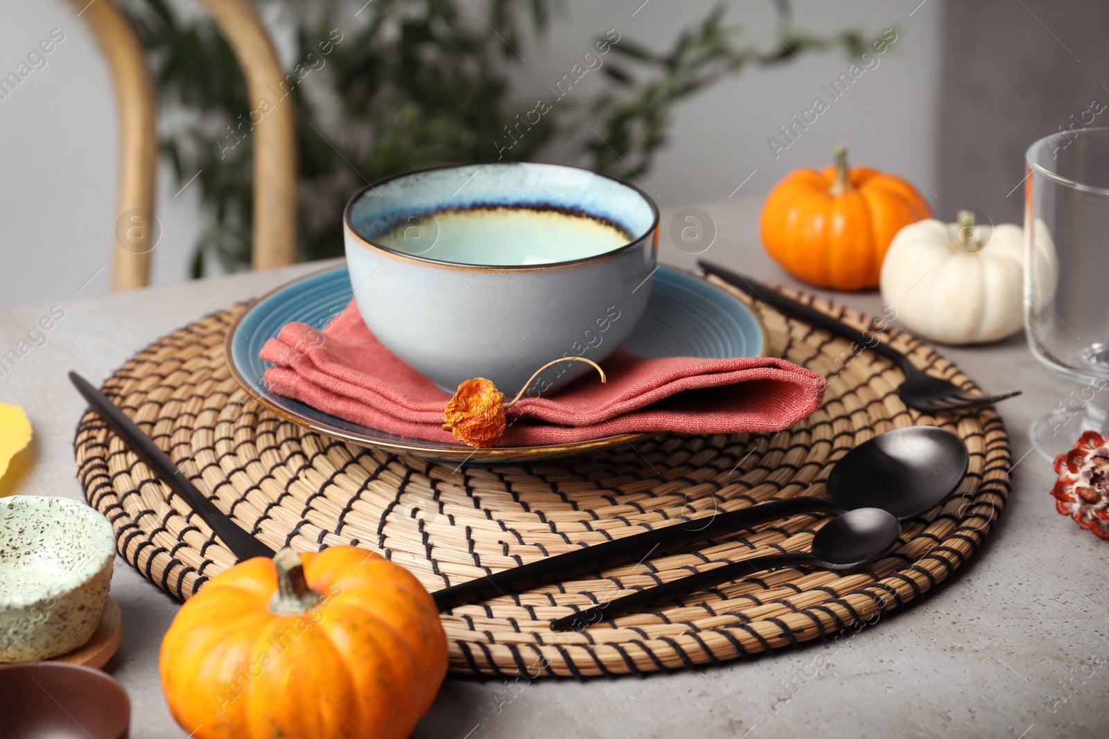 Photo of Seasonal table setting with pumpkins and other autumn decor in dining room