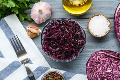 Tasty red cabbage sauerkraut and different ingredients on light grey table, flat lay