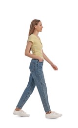 Photo of Young woman in casual outfit walking on white background