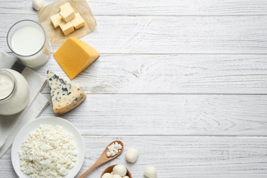 Different dairy products on white wooden table, flat lay. Space for text