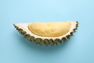 Photo of Piece of fresh ripe durian on light blue background, top view