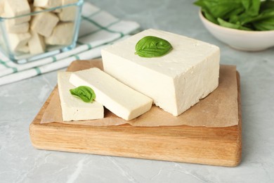Photo of Delicious tofu with basil served on grey marble table