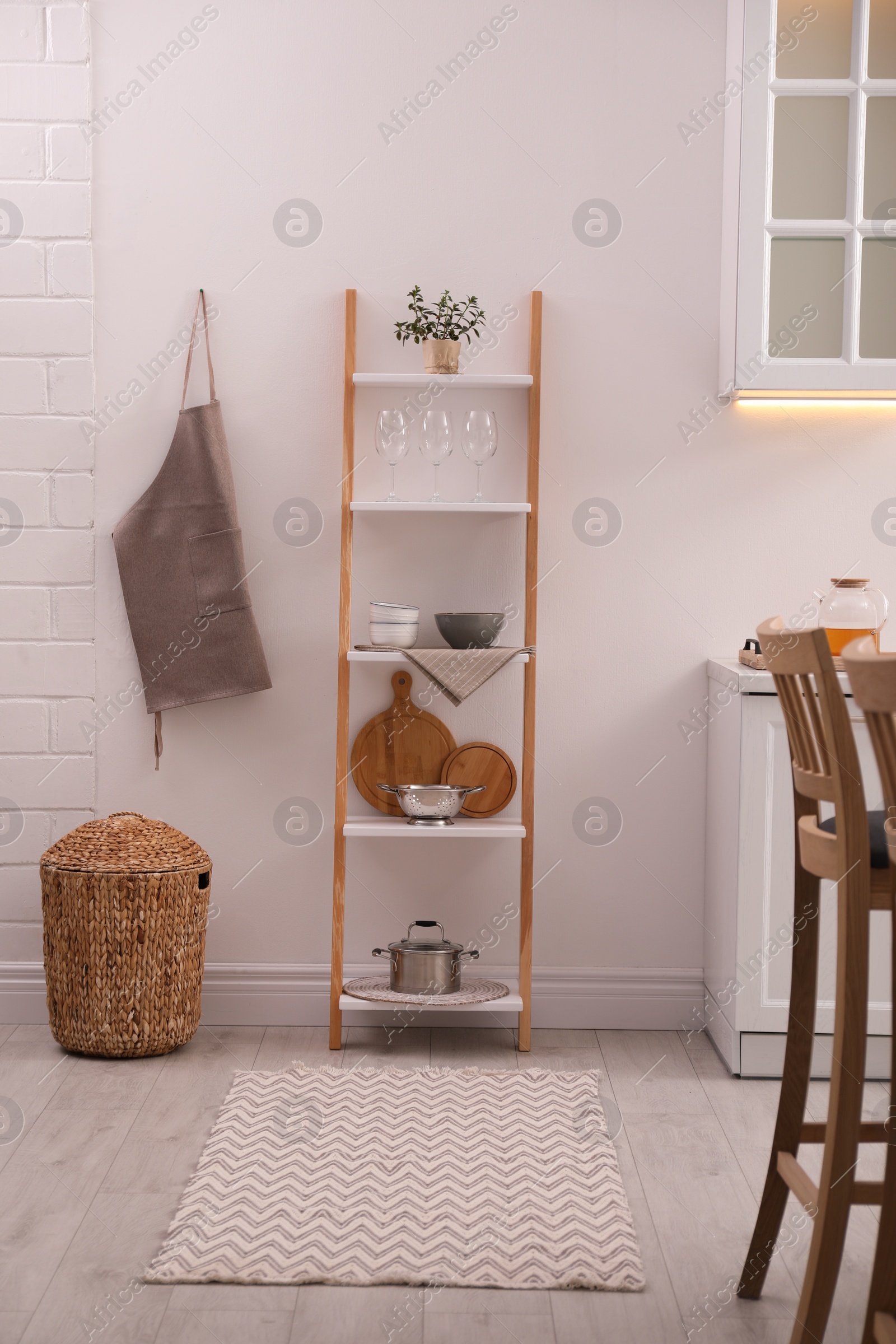 Photo of Stylish kitchen room interior with wooden ladder near white wall