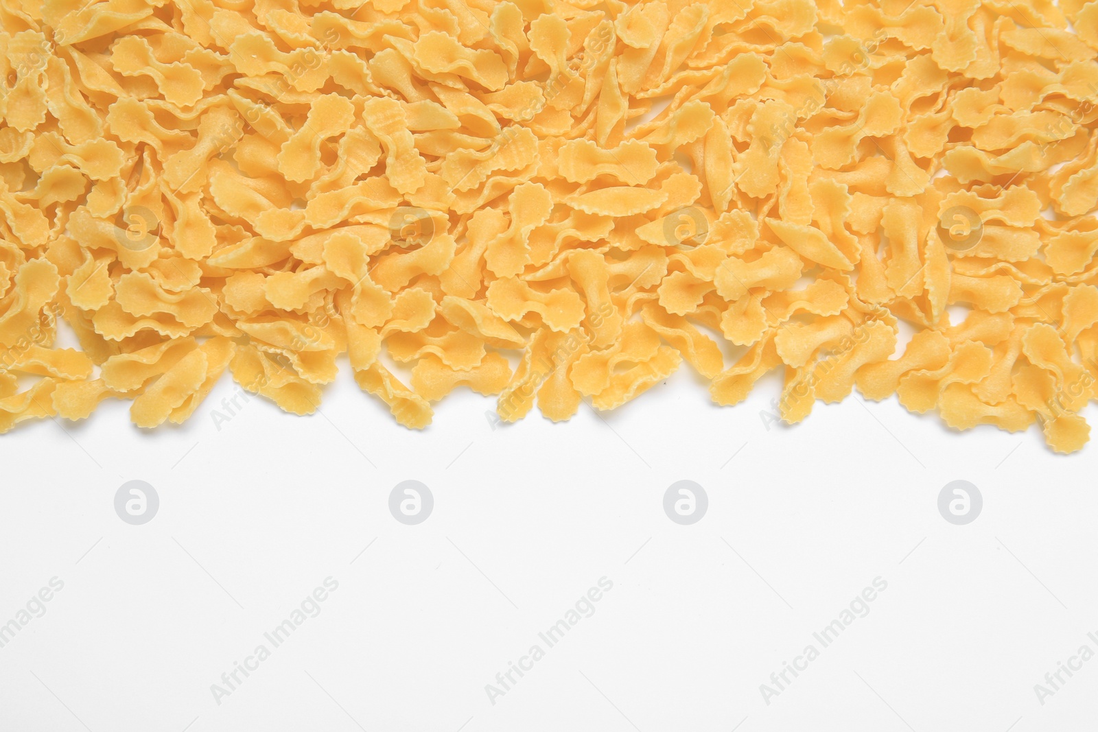 Photo of Raw farfalline pasta on white background, top view. Space for text