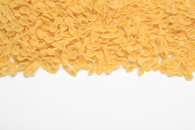 Raw farfalline pasta on white background, top view. Space for text