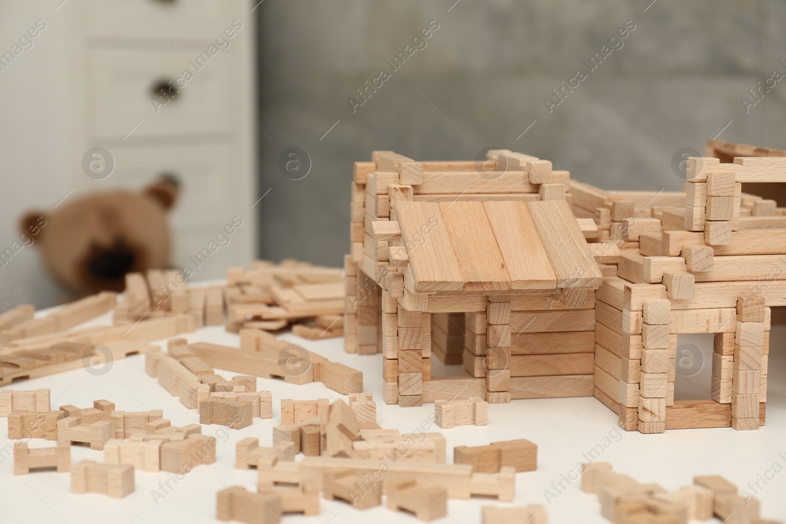 Photo of Wooden construction set on white table indoors, space for text. Children's toy