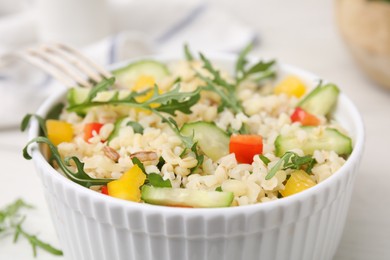 Cooked bulgur with vegetables in bowl on white table, closeup