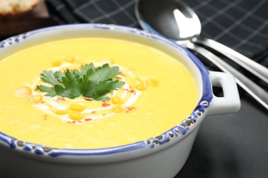 Photo of Delicious creamy corn soup served on table, closeup