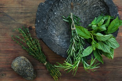 Photo of Thyme and rosemary on wooden table, above view with space for text. Aromatic herbs