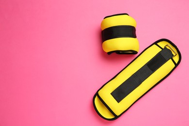 Photo of Yellow weighting agents on pink background, flat lay. Space for text