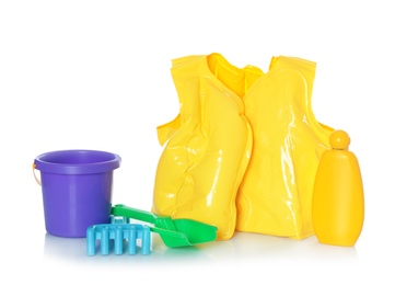 Photo of Inflatable vest and beach toys on white background