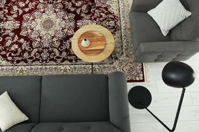 Photo of Cozy room interior with stylish furniture and soft carpet with beautiful pattern, top view