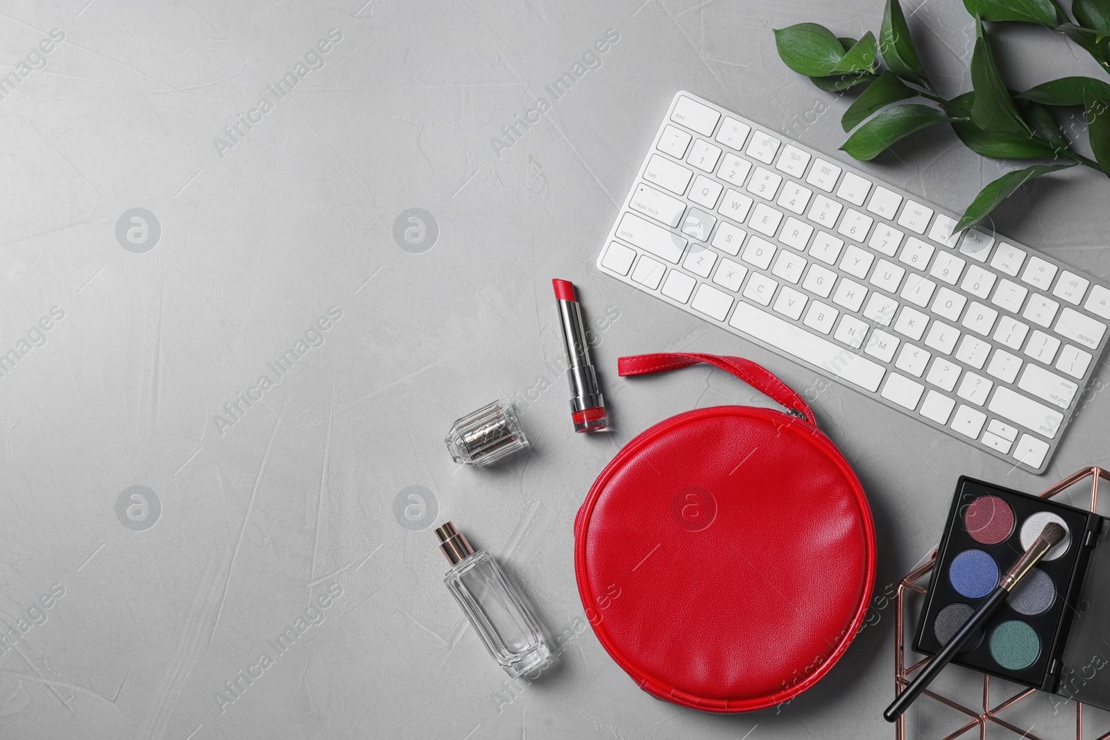 Photo of Flat lay composition with keyboard and cosmetics on stone surface, space for text. Beauty blogger