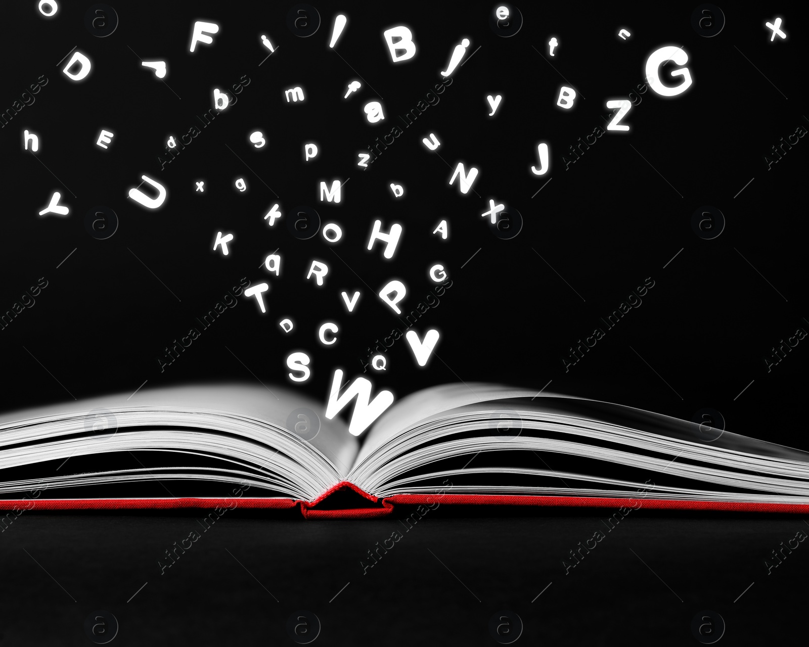 Image of Letters flying out from open book on black background, closeup