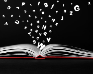 Image of Letters flying out from open book on black background, closeup