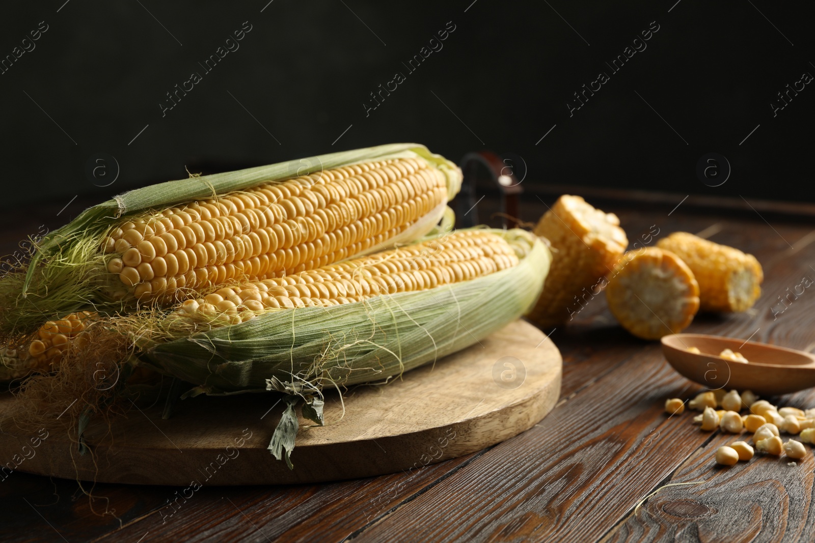 Photo of Tasty sweet corn cobs on wooden table