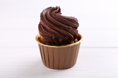 Photo of Delicious chocolate cupcake on white wooden table, closeup