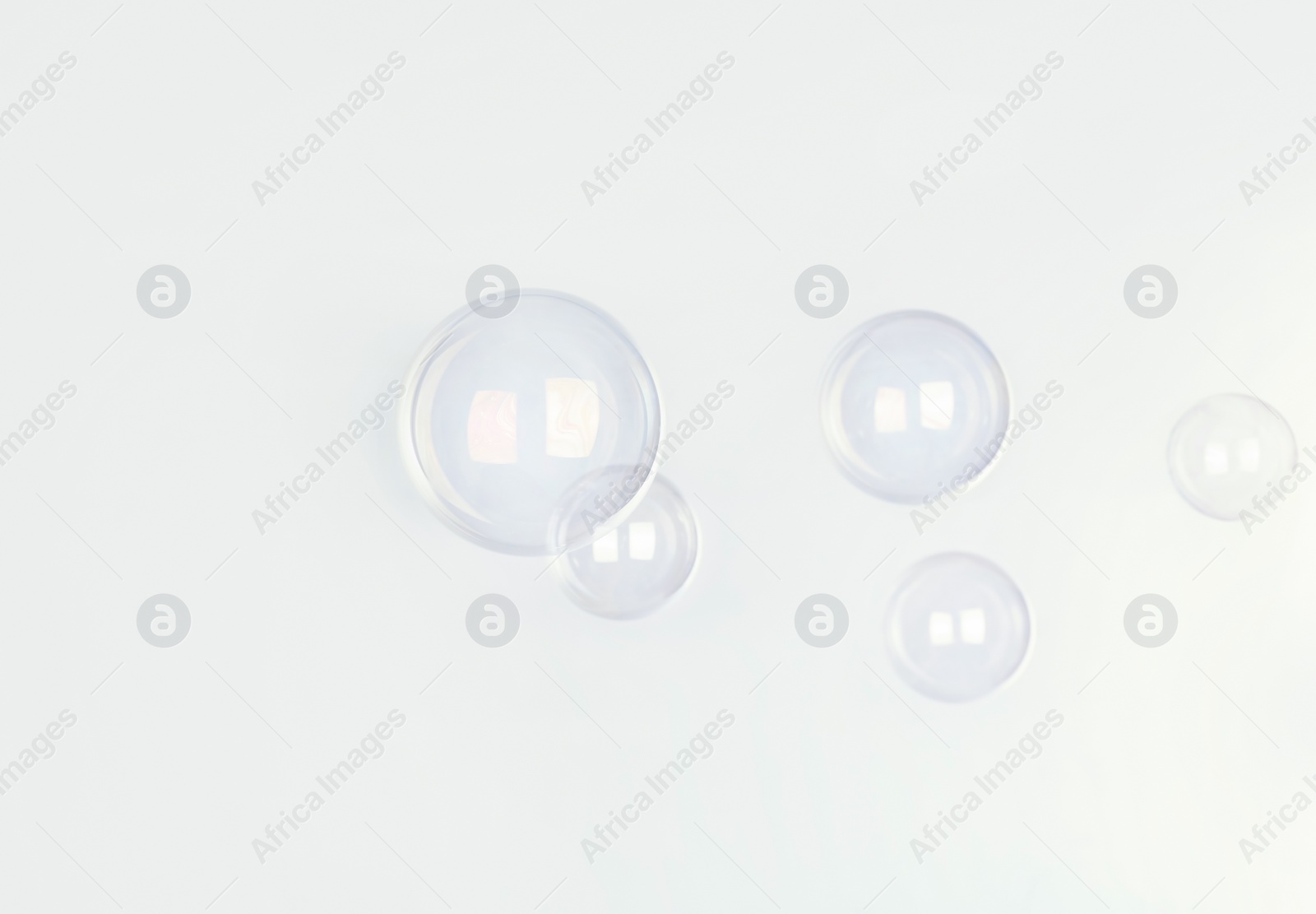 Photo of Beautiful translucent soap bubbles on light background. Space for text