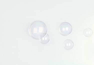 Photo of Beautiful translucent soap bubbles on light background. Space for text