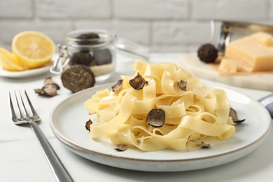 Photo of Delicious pasta with truffle slices served on white table