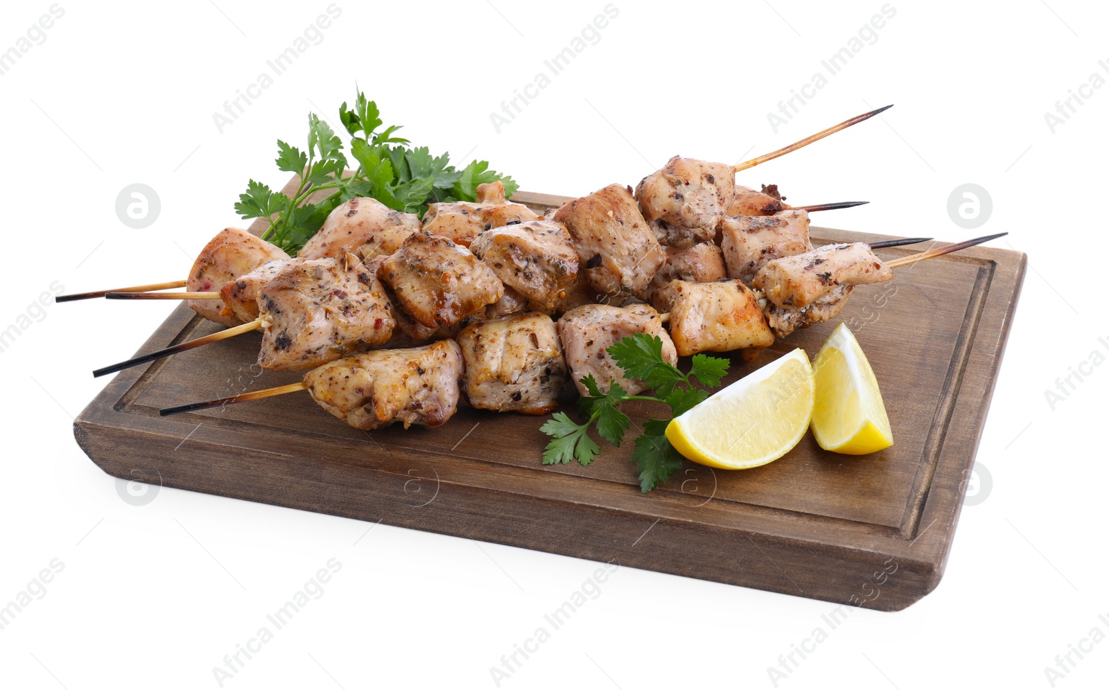 Photo of Wooden board with delicious fresh shish kebabs, parsley and lemon isolated on white