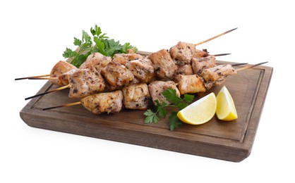 Photo of Wooden board with delicious fresh shish kebabs, parsley and lemon isolated on white