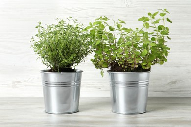 Photo of Different aromatic potted herbs on light wooden table