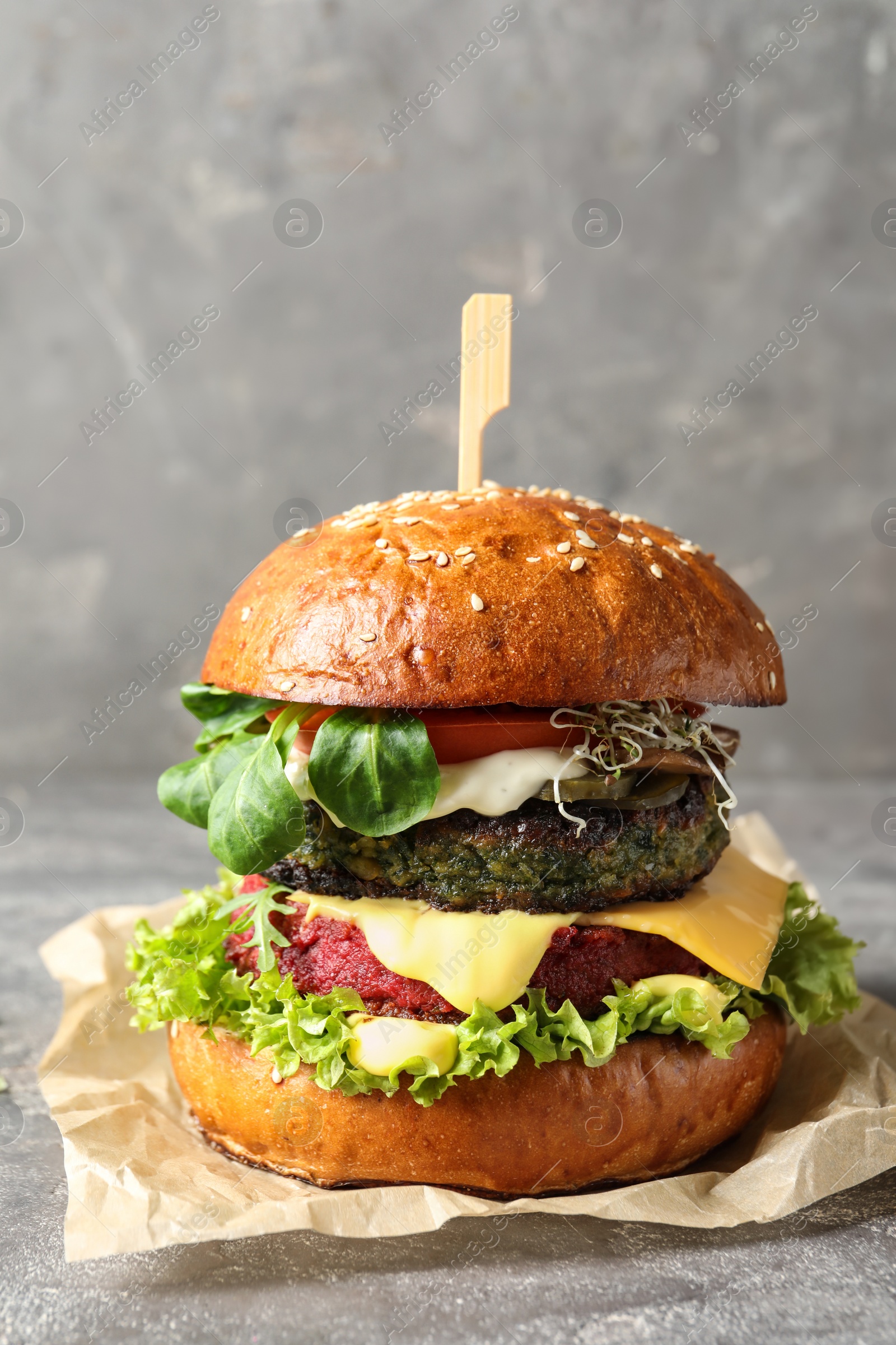 Photo of Vegan burger with beet and falafel patties on table