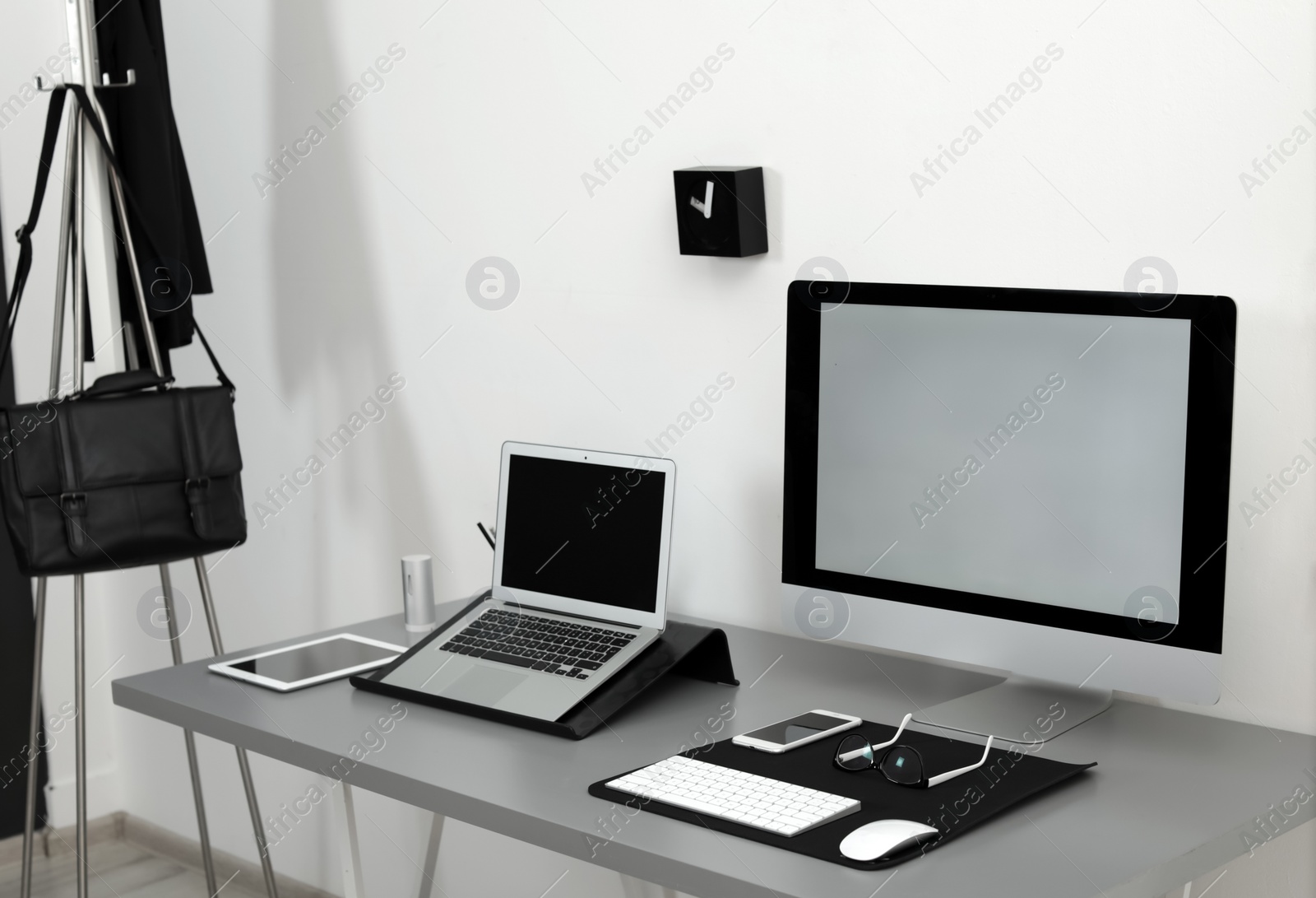 Photo of Modern workplace interior with computers on table. Space for text