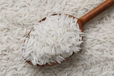 Photo of Raw basmati rice and spoon as background, top view