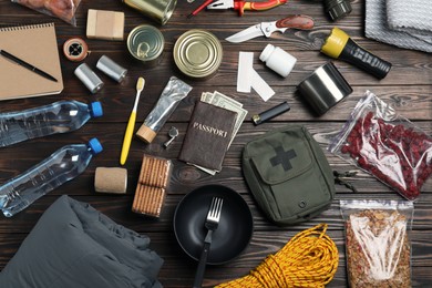 Photo of Disaster supply kit for earthquake on wooden table, flat lay
