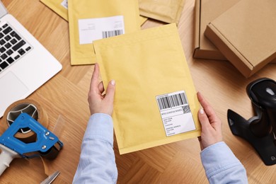 Post office worker packing parcel at wooden table, top view