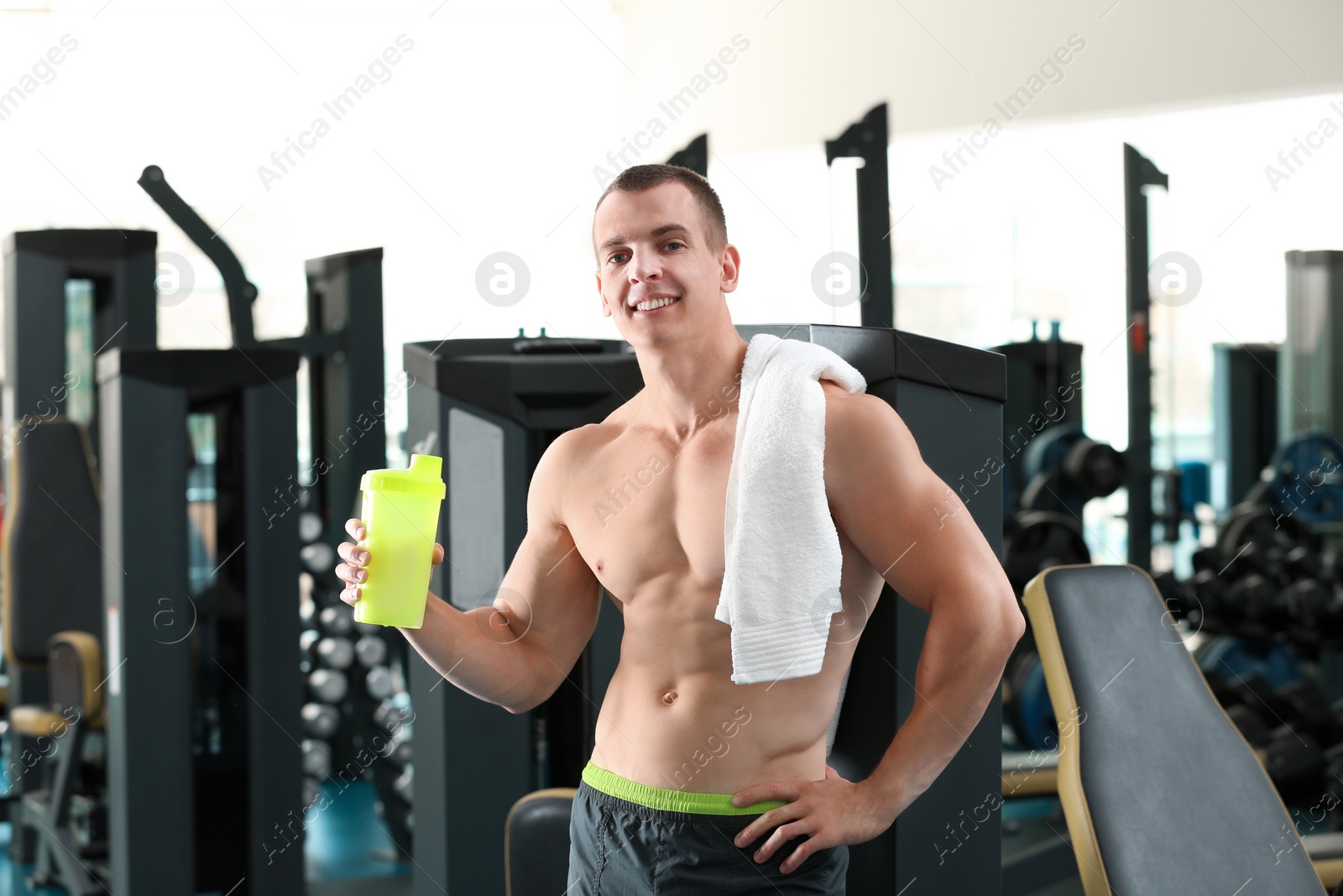 Photo of Athletic young man with protein shake in gym