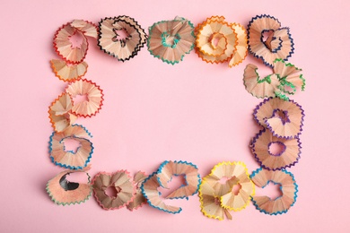 Photo of Frame made of pencil shavings on pink background, top view. Space for text