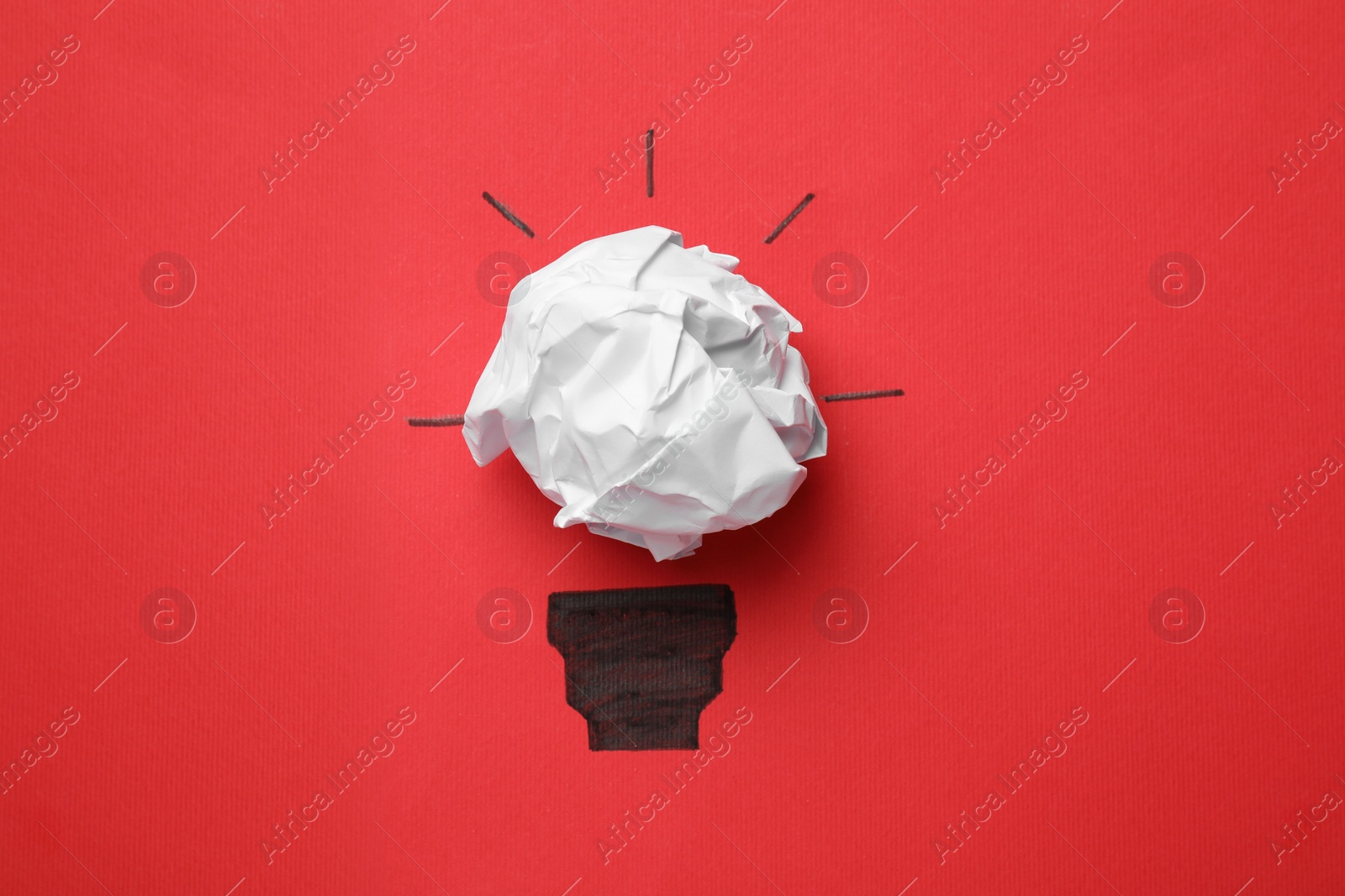 Photo of Idea concept. Light bulb made with crumpled paper and drawing on red background, top view