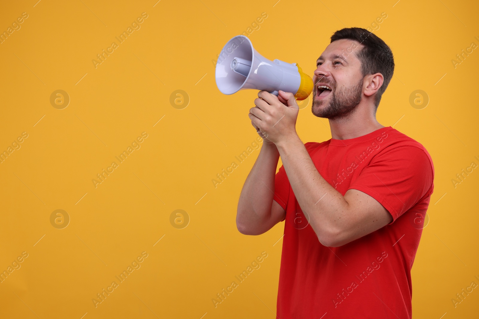Photo of Special promotion. Man shouting in megaphone on orange background. Space for text
