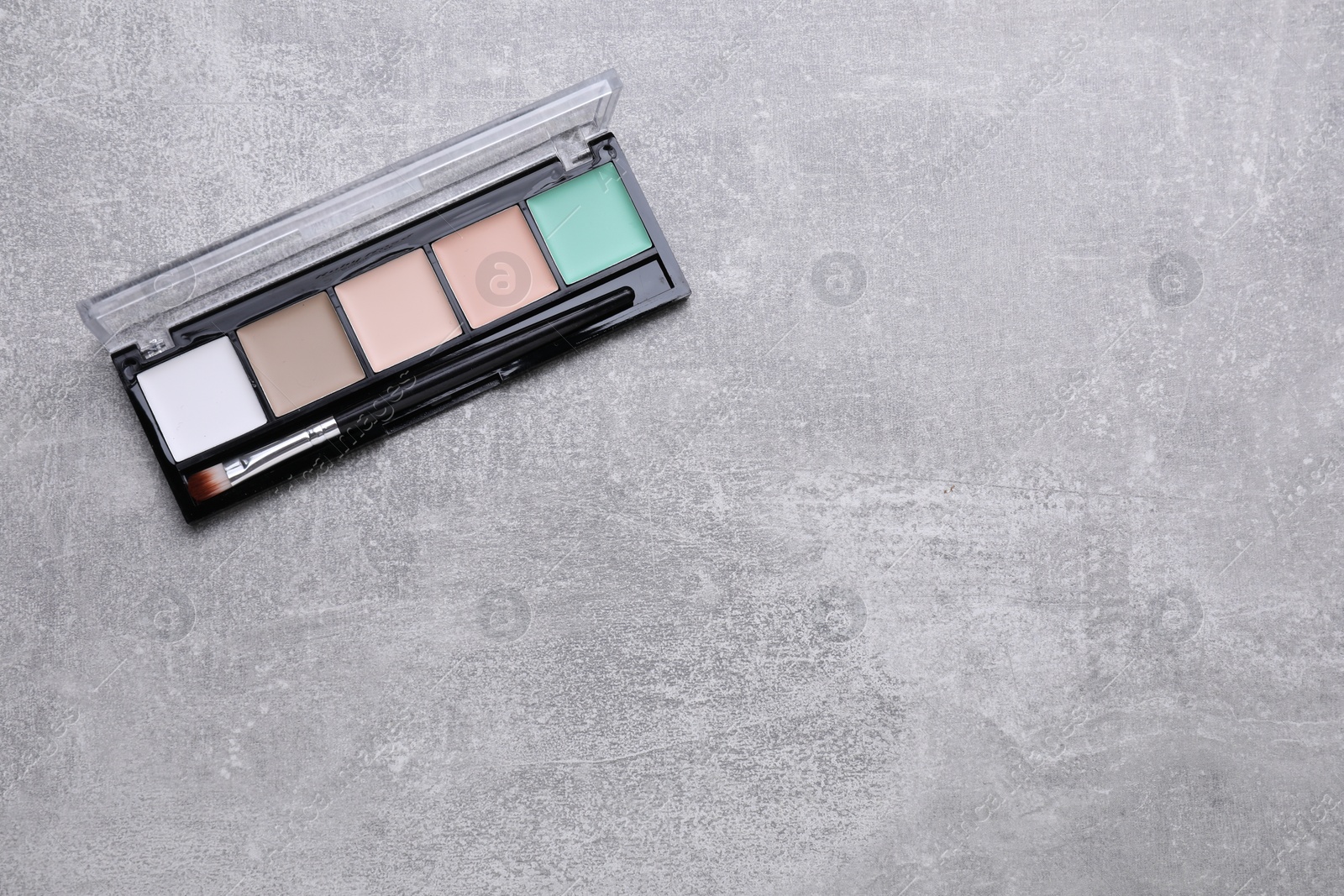 Photo of Contouring palette with brush on light gray background, top view and space for text. Professional cosmetic product