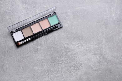 Contouring palette with brush on light gray background, top view and space for text. Professional cosmetic product