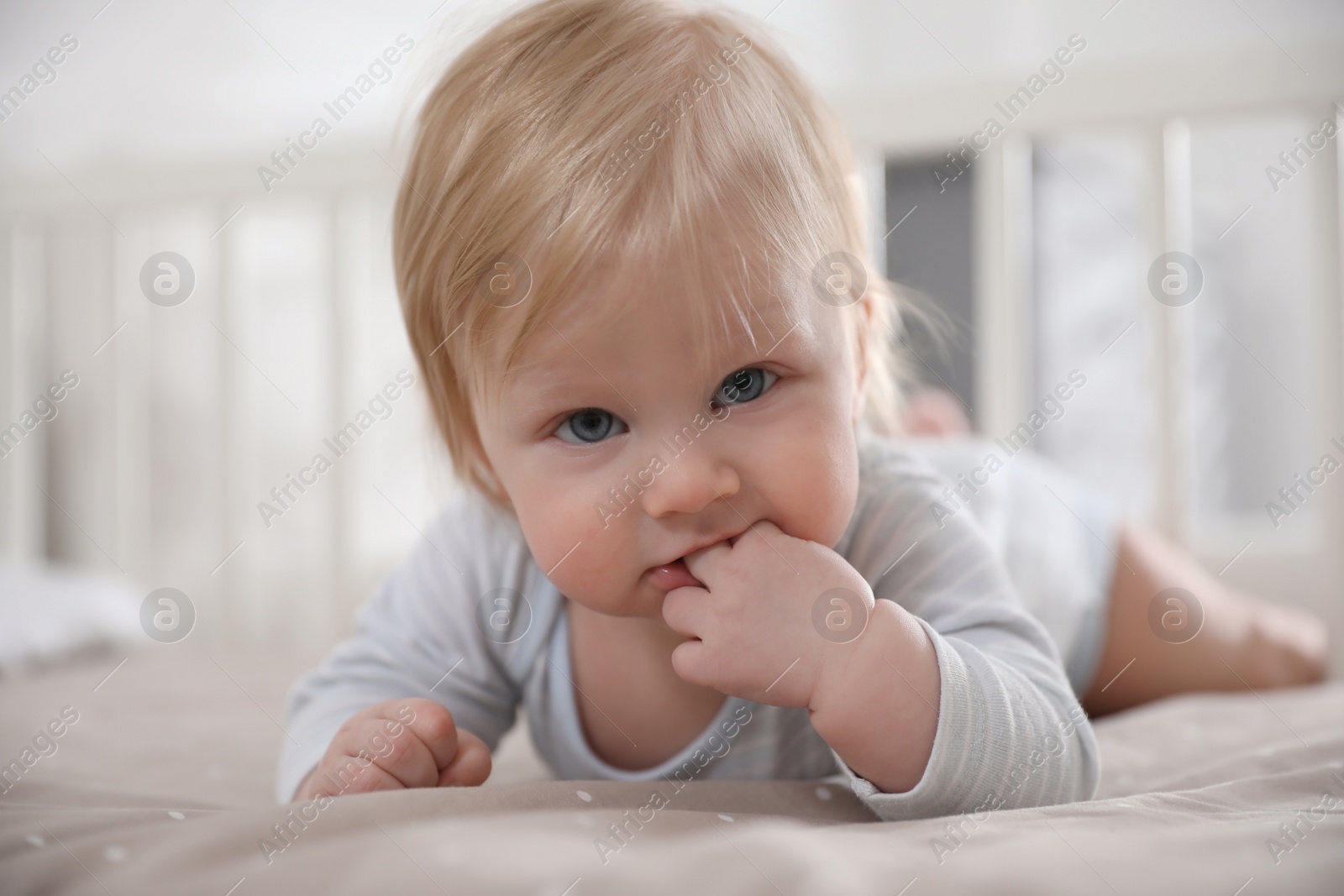 Photo of Adorable little baby lying in comfortable crib