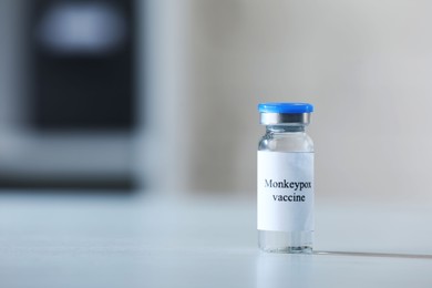 Photo of Monkeypox vaccine in vial on white table, space for text