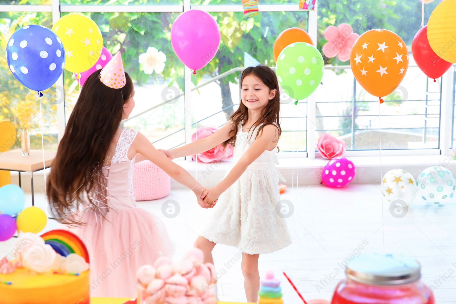 Photo of Cute girls playing together at birthday party indoors