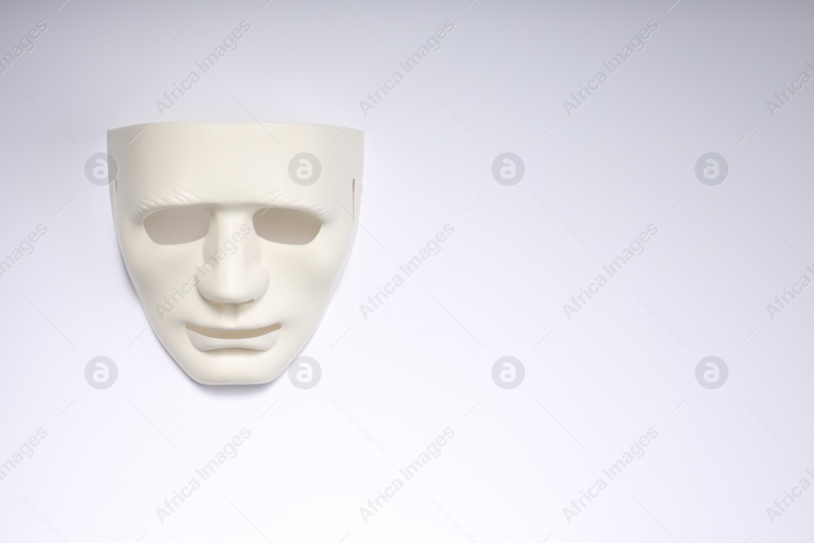 Photo of Theater arts. Plastic mask on white background, top view. Space for text