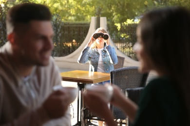 Photo of Jealous ex girlfriend spying on couple in outdoor cafe