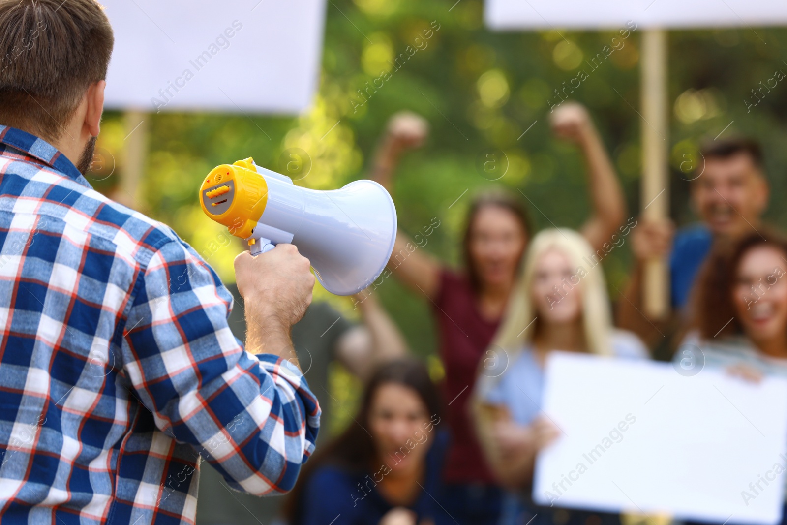 Image of Protest leader with megaphone talking to crowd outdoors