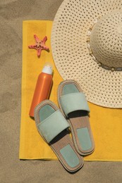 Sunscreen, starfish and beach accessories on sand, top view. Sun protection care