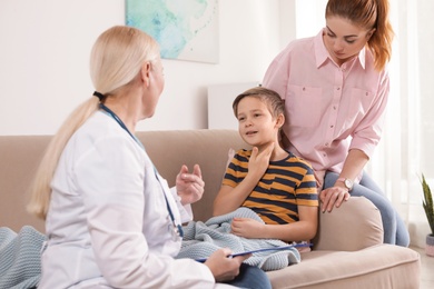 Family doctor visiting ill child at home