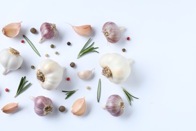 Photo of Fresh garlic, rosemary and peppercorns on white background, flat lay. Space for text